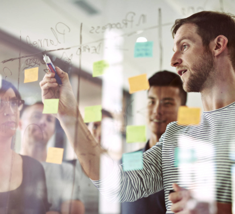 A man explain something on a transparent board